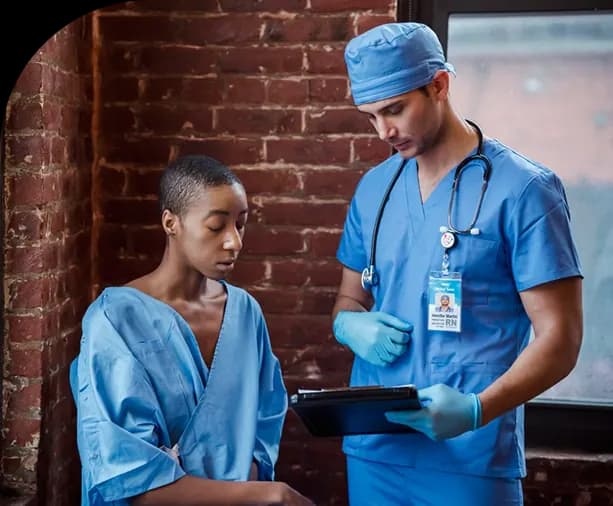 Nurse reviewing information on a tablet with a patient